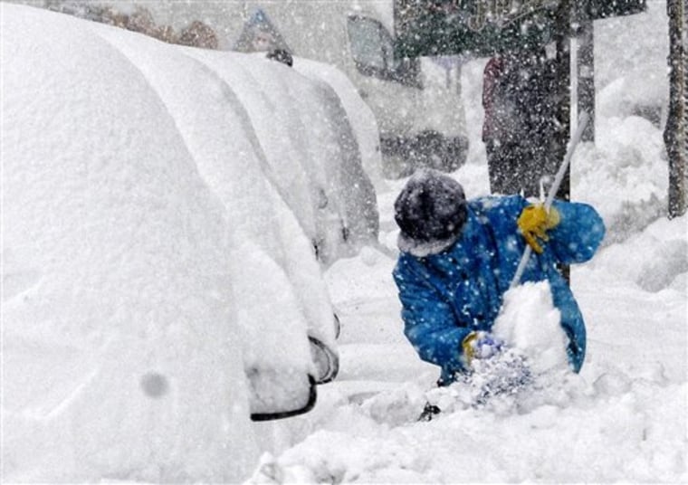 A woman shovels snow in downtown Podgorica, Montenegro, Saturday, Feb. 11, 2012. Montenegro is struggling to maintain its power grid amid record low temperatures in the Balkan country and much of Europe. (AP Photo/Risto Bozovic)
